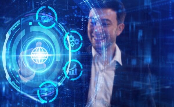 blue colours businessman smiling and looking at holographic interface with icons touching it with his finger