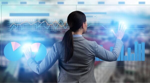 business woman with back view facing a dashboard with clear background arms spread out lighting up the dashboard using touch